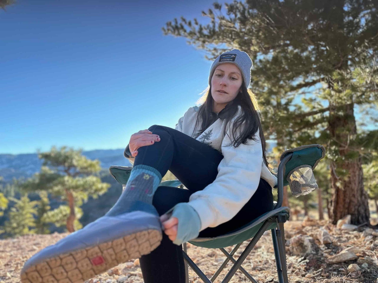 Woman at camp in high desert showing off the great traction on the soles of the North Face ThermoBall Traction Mules V