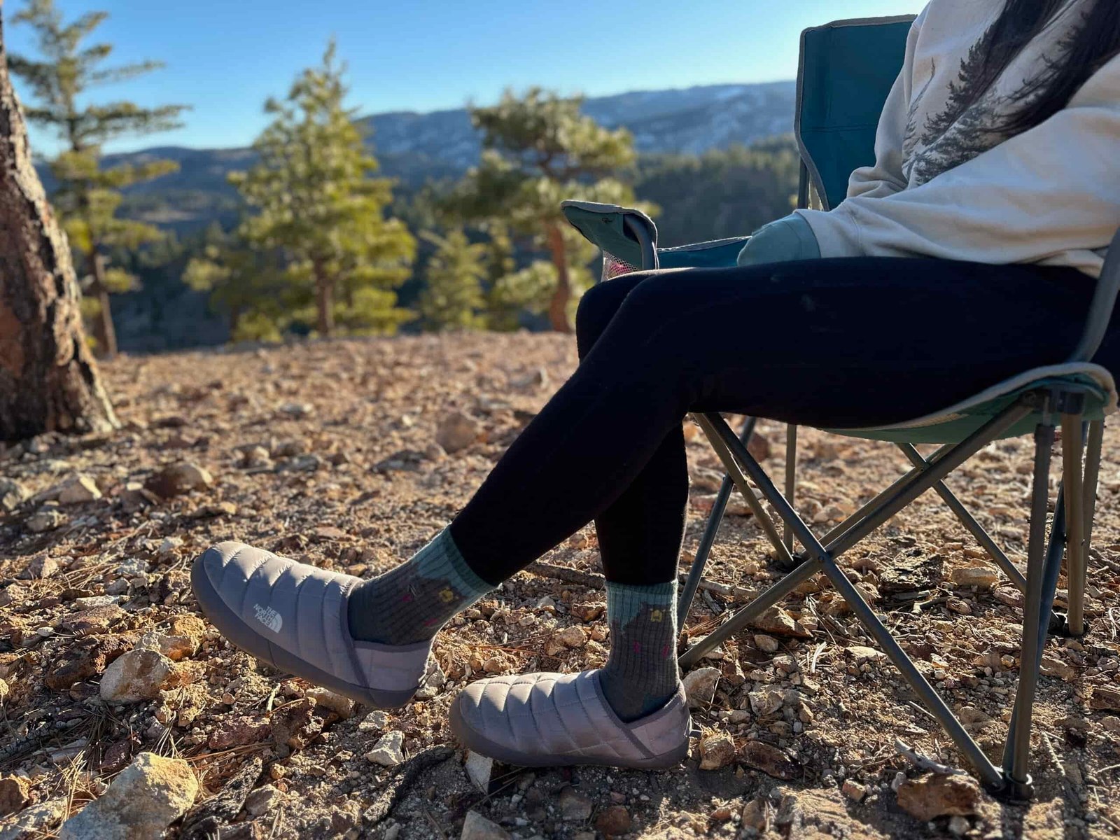 Women showing off North Face ThermoBall Traction Mules V on rocky, high desert camp site