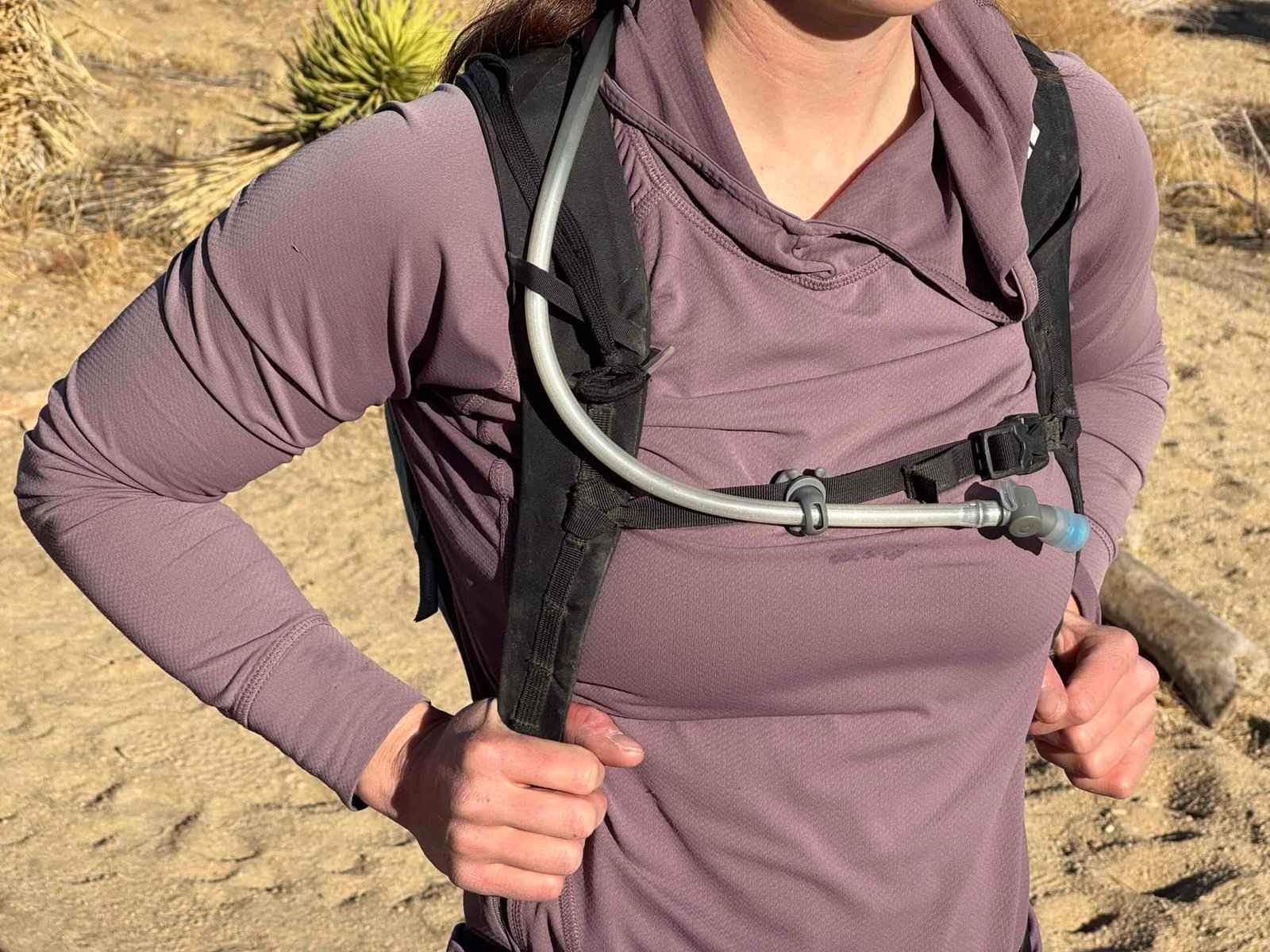 Close up image showing how the HydraPak Contour's hydration hose stays in place while hiking with a sternum strap magnet.