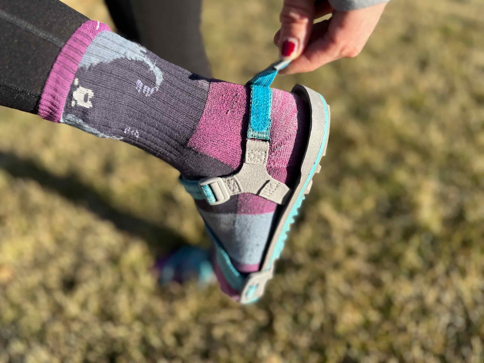 a woman wears the Xero Shoes Z-Trail EV on grass to show off the fit of the shoe