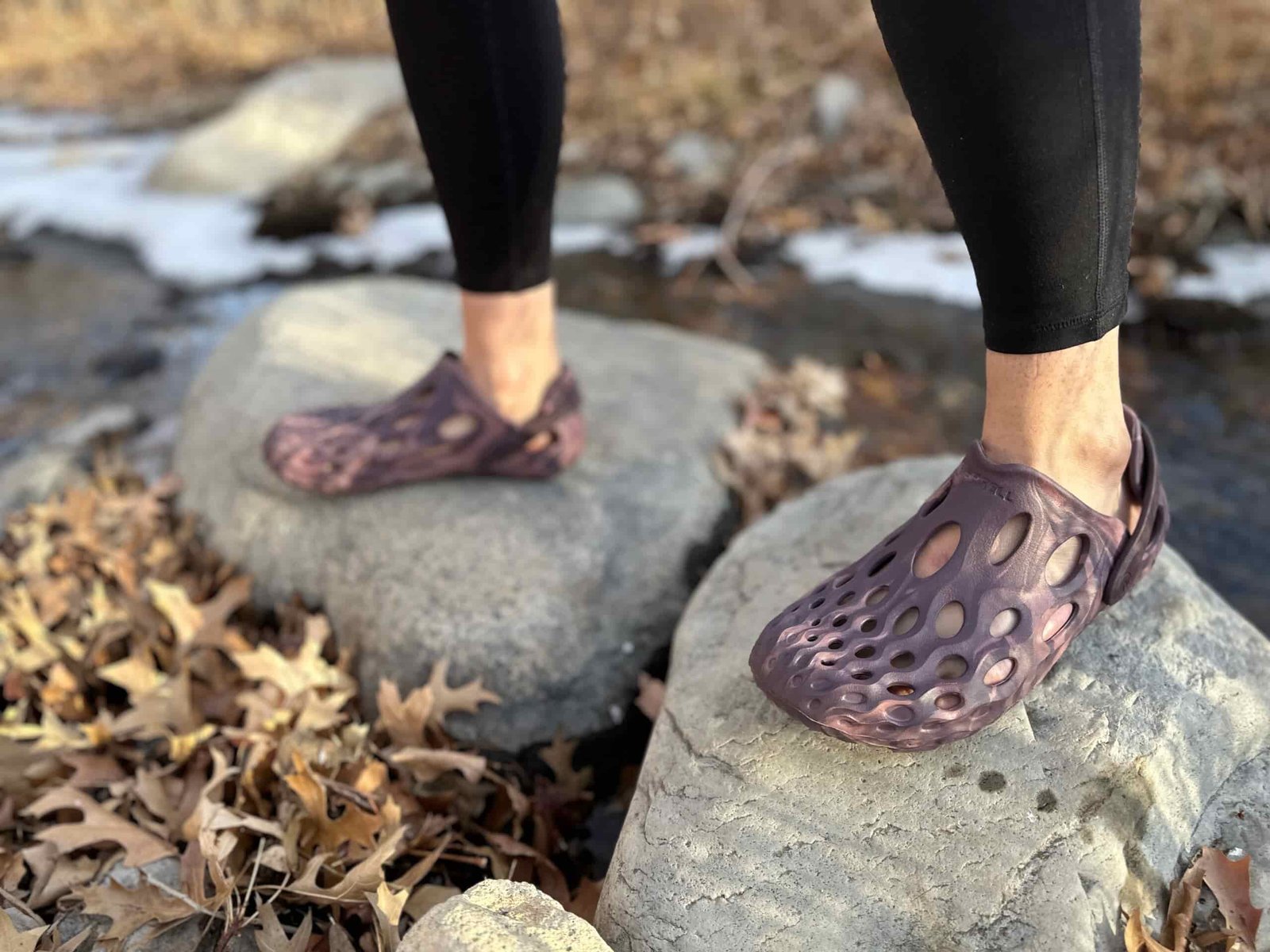a woman wears the Merrell Hydro Moc on rocks by the river