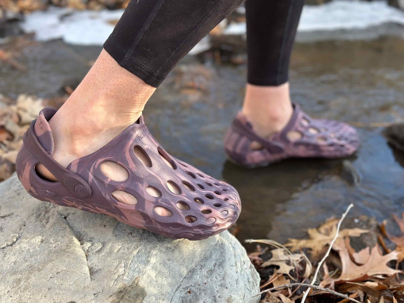a woman wears Merrell Hydro Moc by a creek 