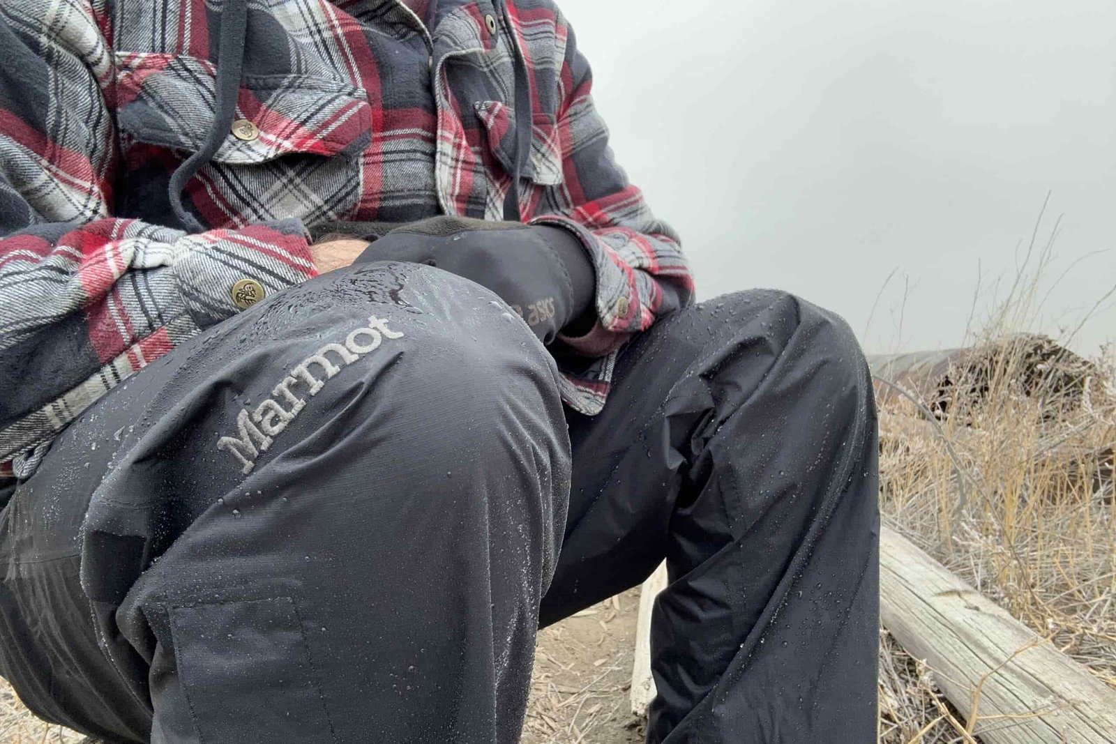 Closeup of someone wearing the black Marmot PreCip Eco rain pants.