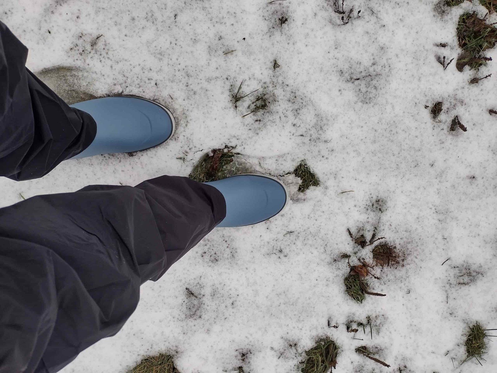 Looking down at someone's feet wearing the light blue Huk Rogue Waves.