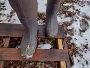 Ground level view of someone wearing the brown Original Muck Boot Wetland standing on a pallet.