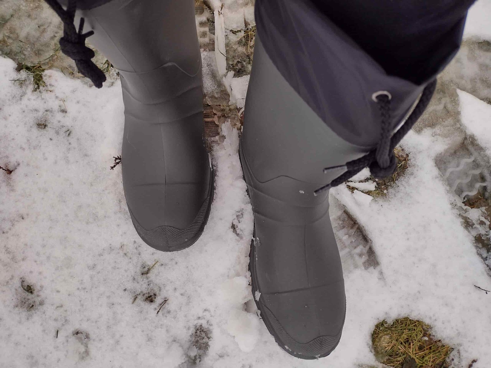 Ground level view of someone wearing the green Kamik Forester on a snowy trail.