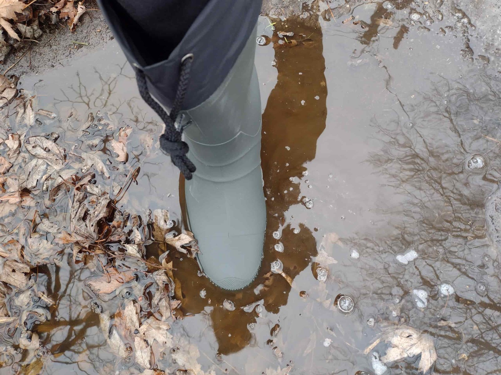 Ground level view of someone wearing the green Kamik Forester in deep water.