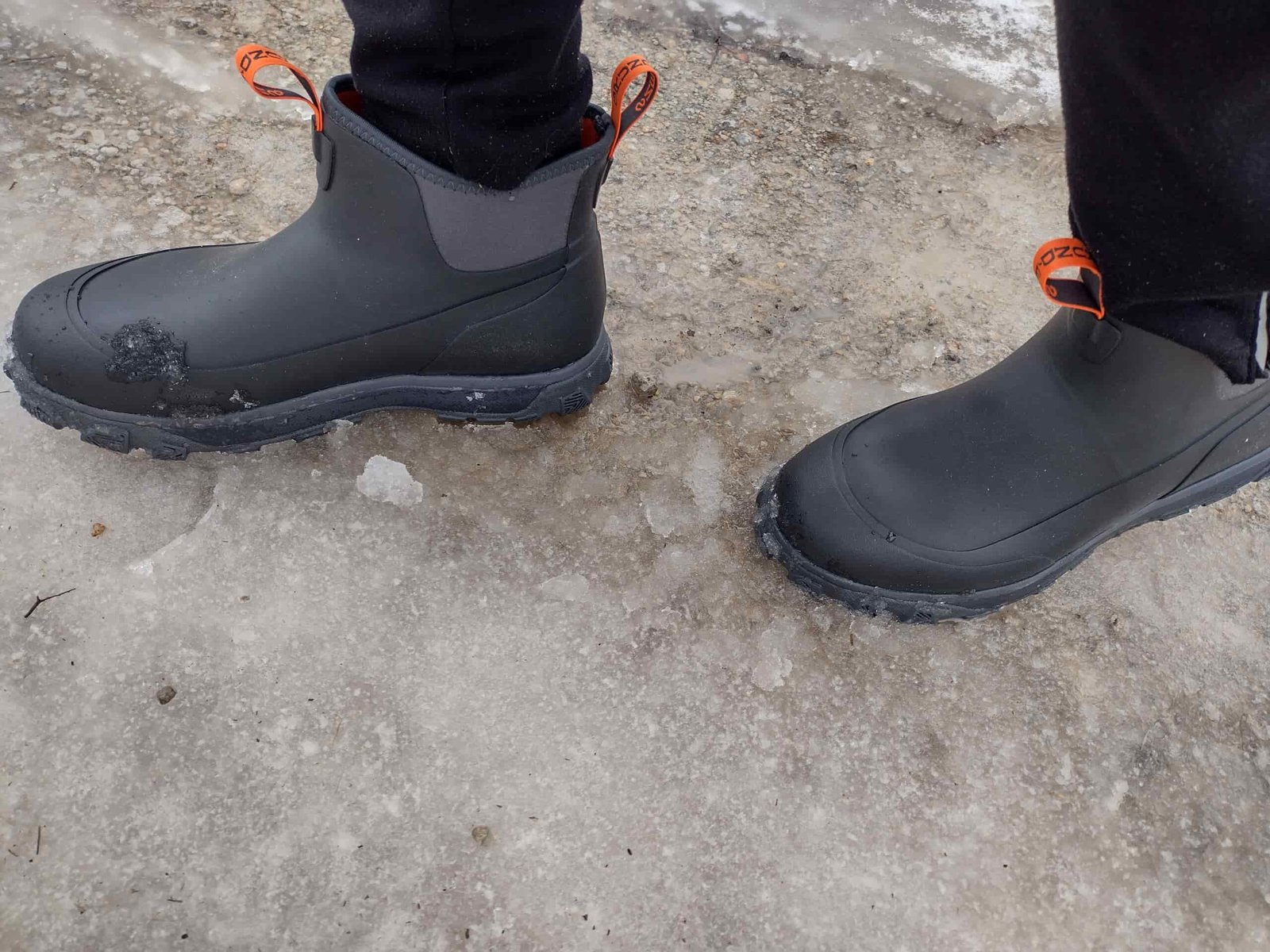 Ground level view of someone wearing the black Grundens Deviation Ankle Boot on ice.