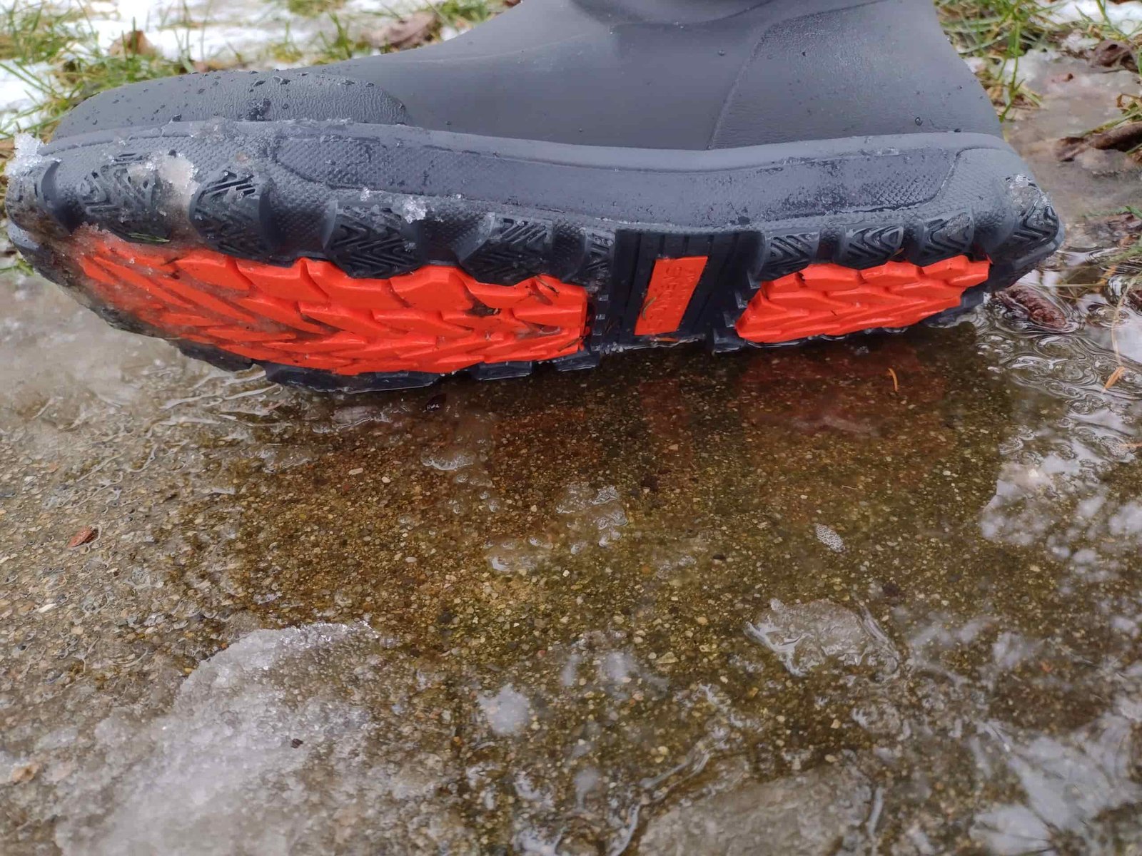 Ground level view of the soles of the black Grundens Deviation Ankle Boot.