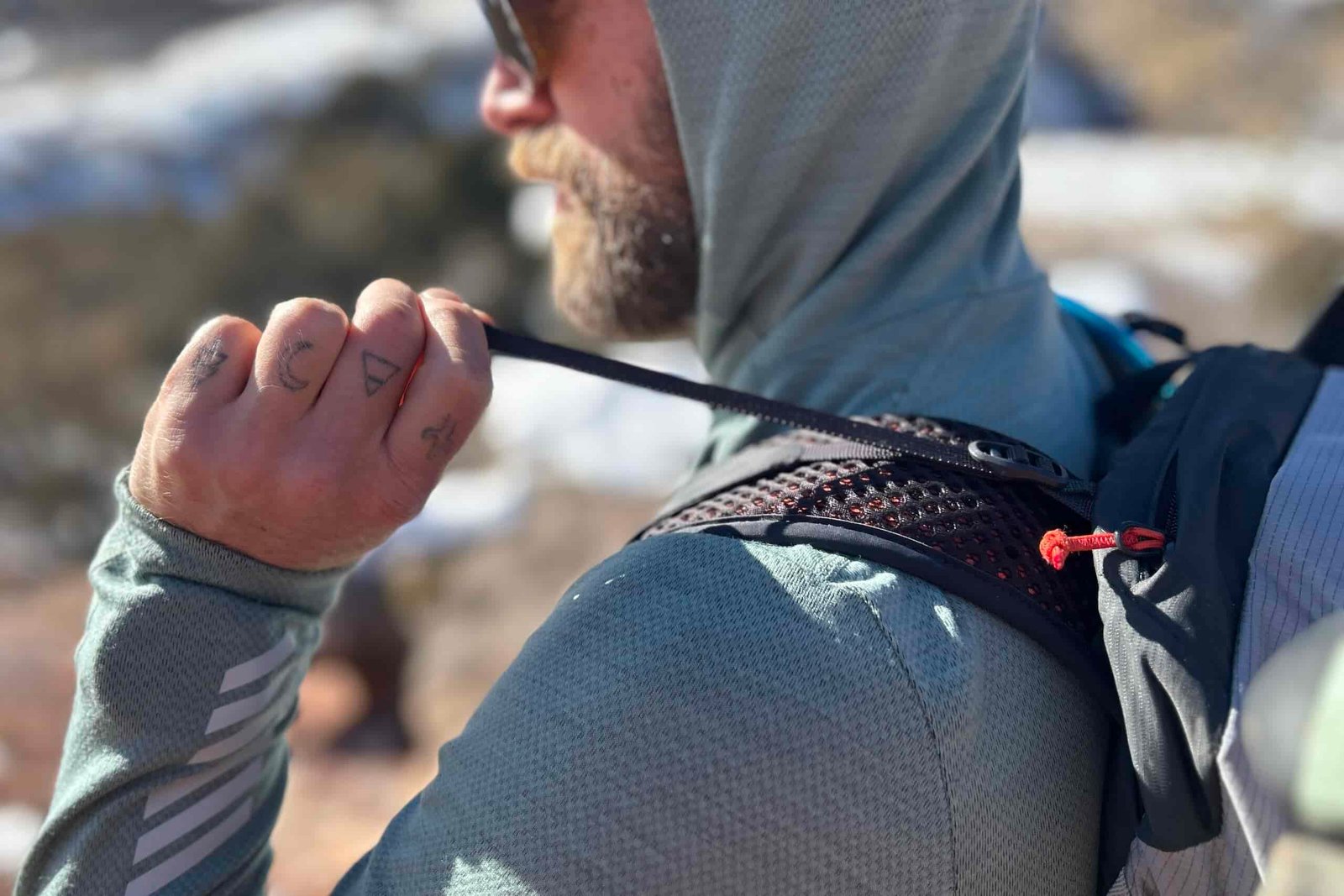 Close up of a person tightening the load lifters on a backpack.