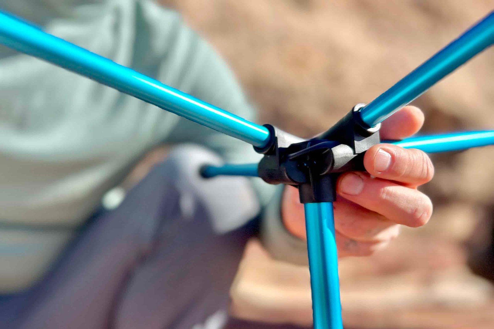 Close up of the connection hub of a camping chair with the poles inserted.