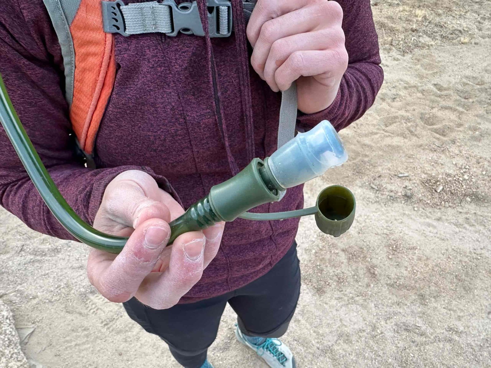 Close up of a hiker holding the bite valve on the Cherainti Bladder