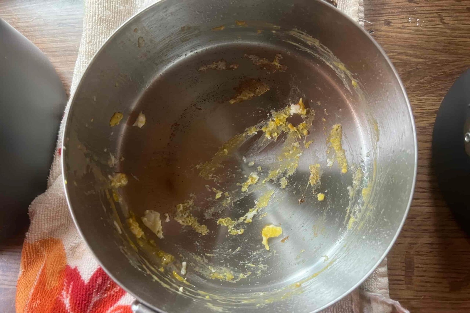 A top down view of a steel pot with egg remnants.