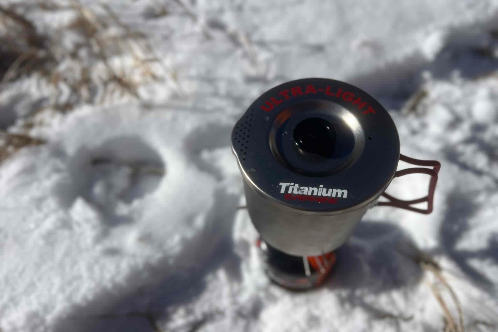 A top shot of the evernew pasta pot with its lid on and sitting on top of a stove with a snowy background.