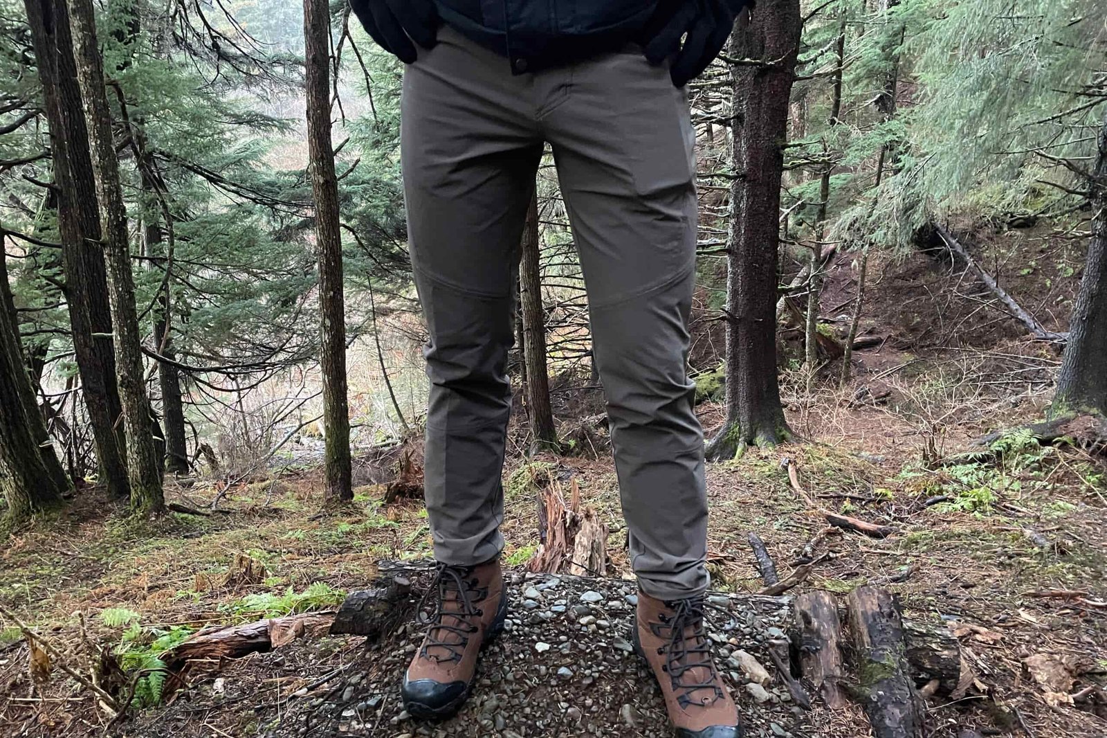 A closeup of hiking pants on a forest trail.