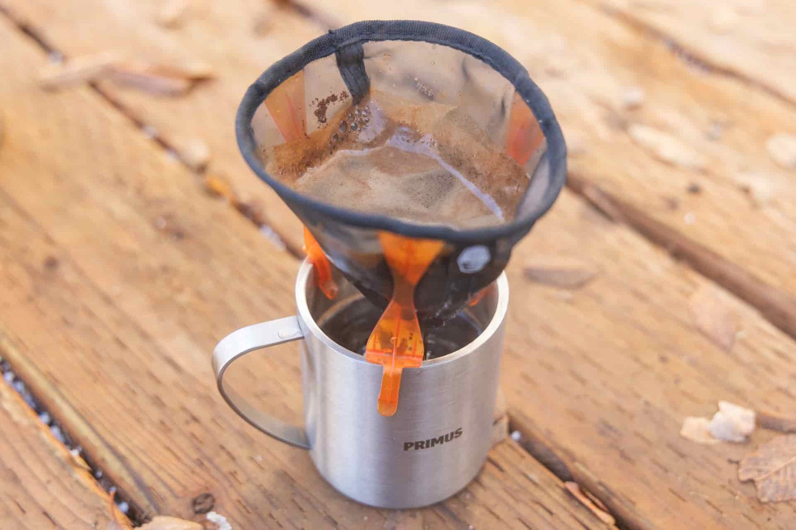 The GSI Ultralight Java Drip full of grounds and water dripping into a camp mug.