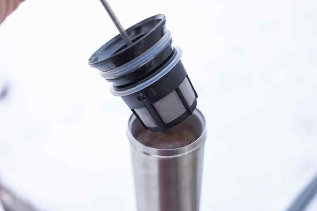 The ESPRO filter hovering above a full mug.