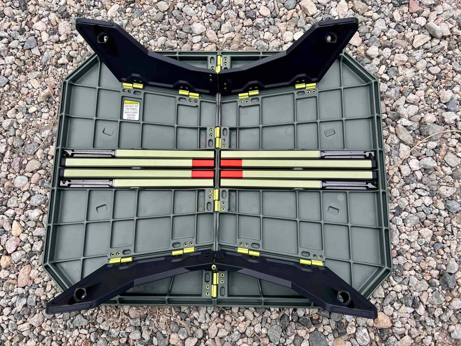 The NEMO Moonlander Dual-Height Camp Table is sitting upside down showing its hinges and folded up legs.