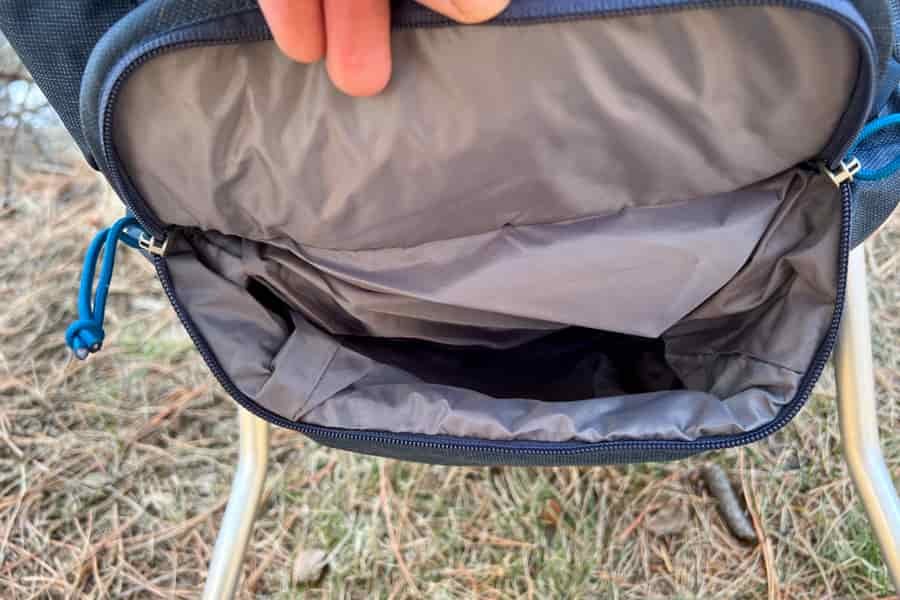 Open storage compartment of a baby carrier showing ample interior space and durable lining.