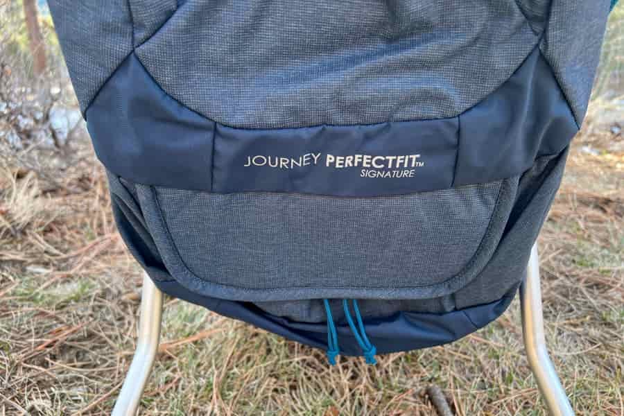 A close-up of the Kelty PerfectFIT Journey Signature's lower storage compartment, highlighting the embroidered branding and material texture.