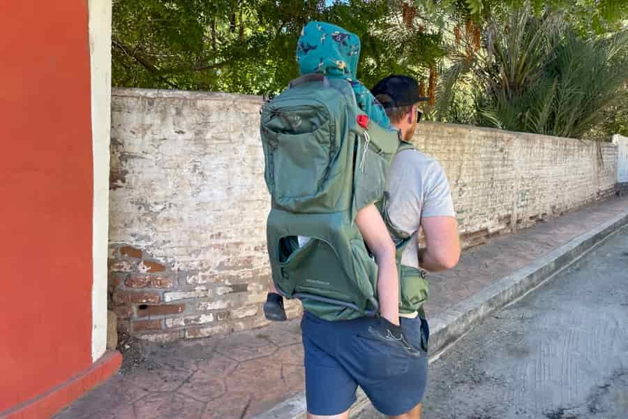 A user walking with the Osprey Poco Premium in an urban environment, showcasing its compact yet spacious design.