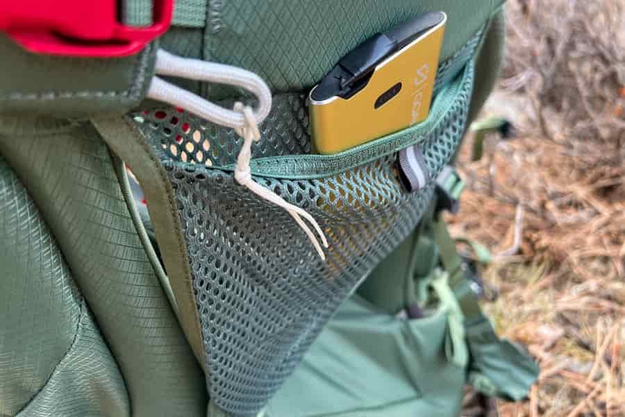 A close-up of the mesh side pocket on the Osprey Poco Premium, holding a small accessory for convenience.