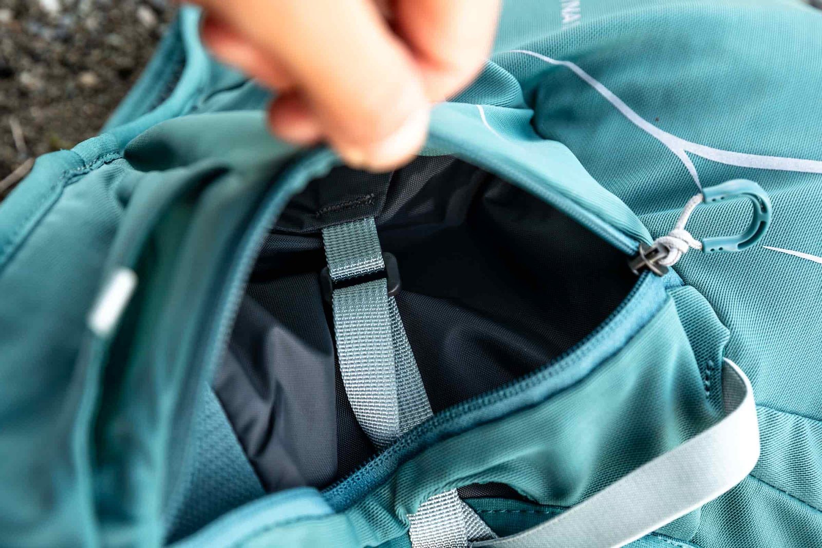 Details of Osprey Dyna 15L - a hand is holding the zippered hip belt pocket open