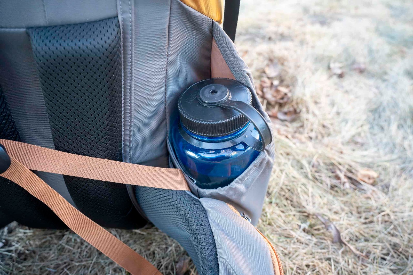 a water bottle in a side pocket of a bakpack