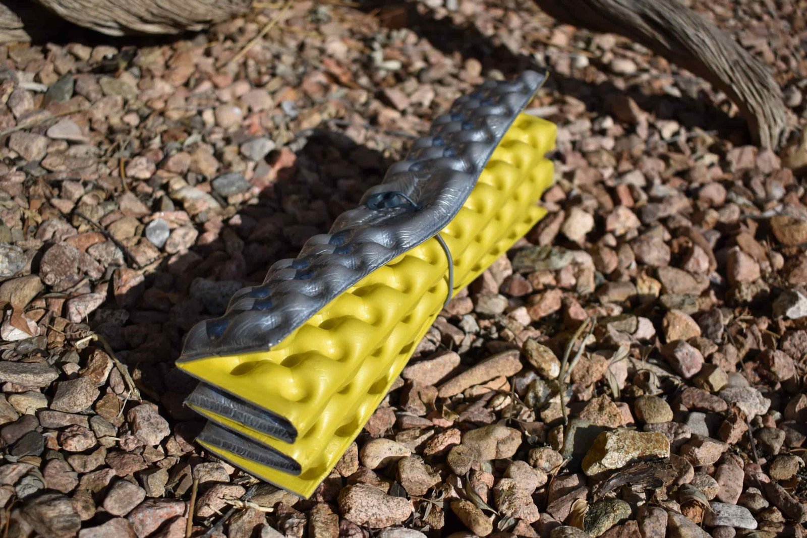 Z-Seat foam sit pad is folded up and laying in a bed of rocks
