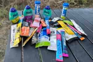 Semi-aerial view of dozens of electrolyte powders and mixes on a camping table