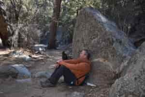a hiker rests in the Hex chair in a desert wash