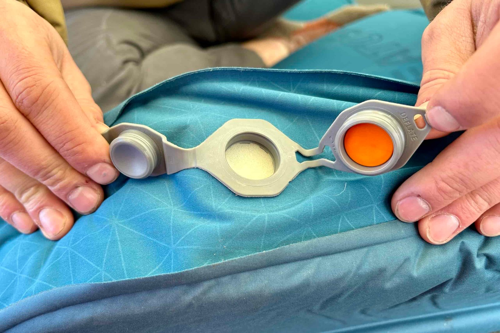 Close-up image of the intake valve with two caps on a camping mattress.