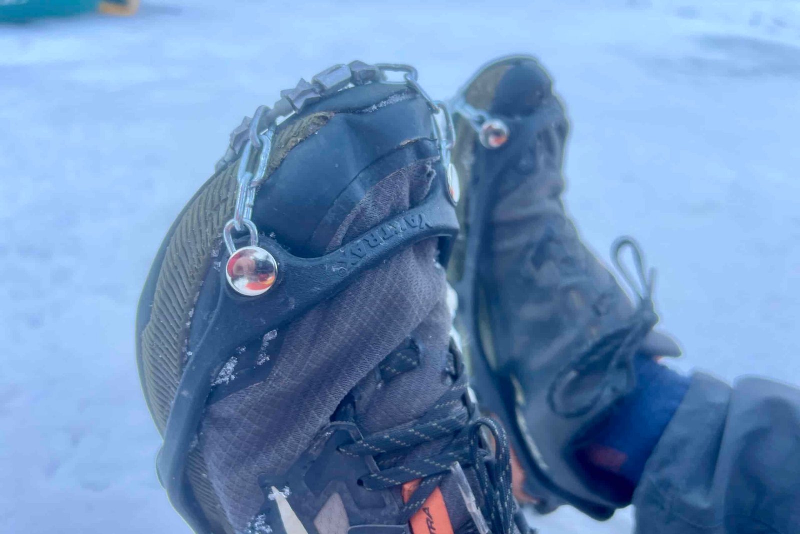 A close up of a pair of ice cleats on hiking shoes.