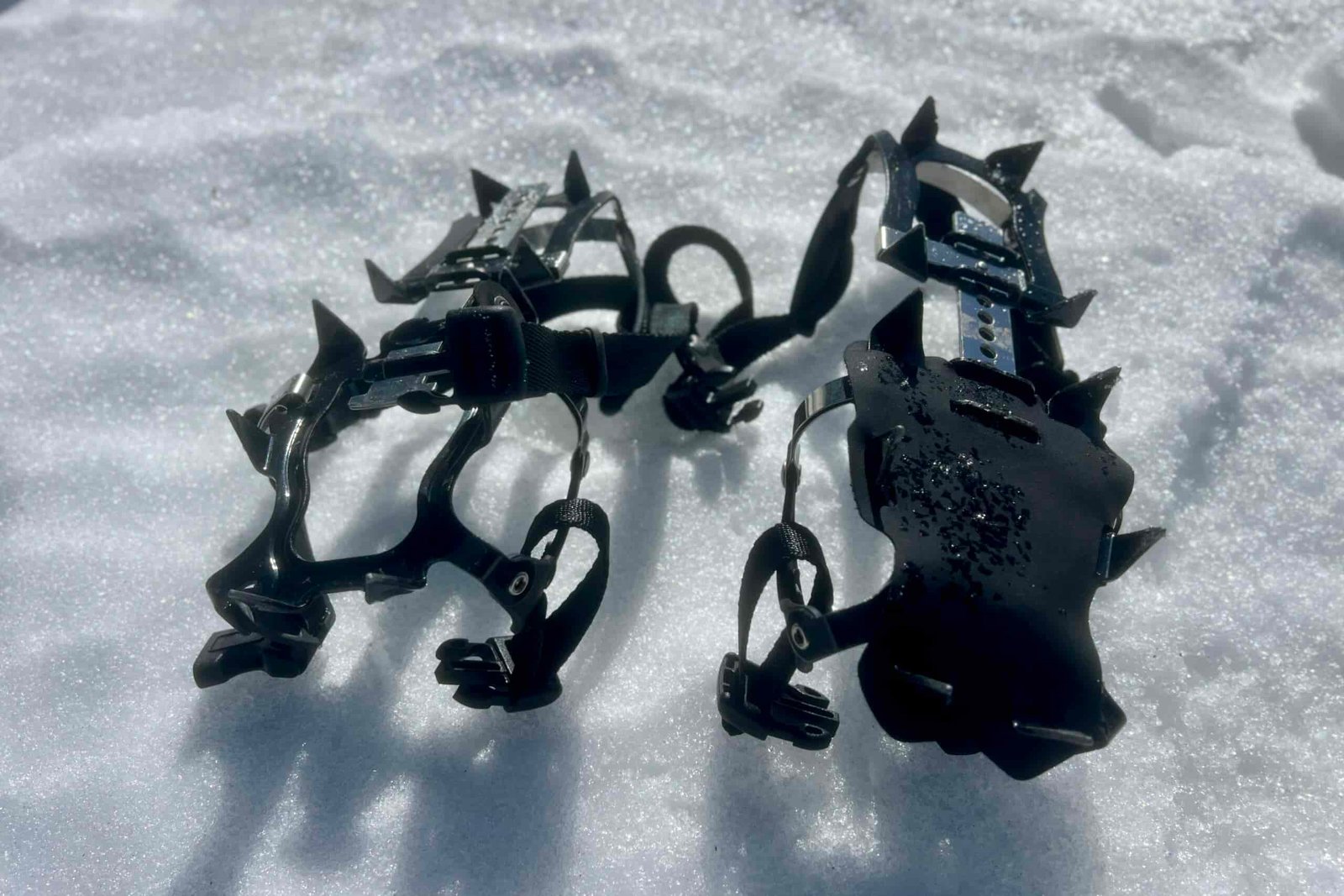 A pair of trail crampons on snow.