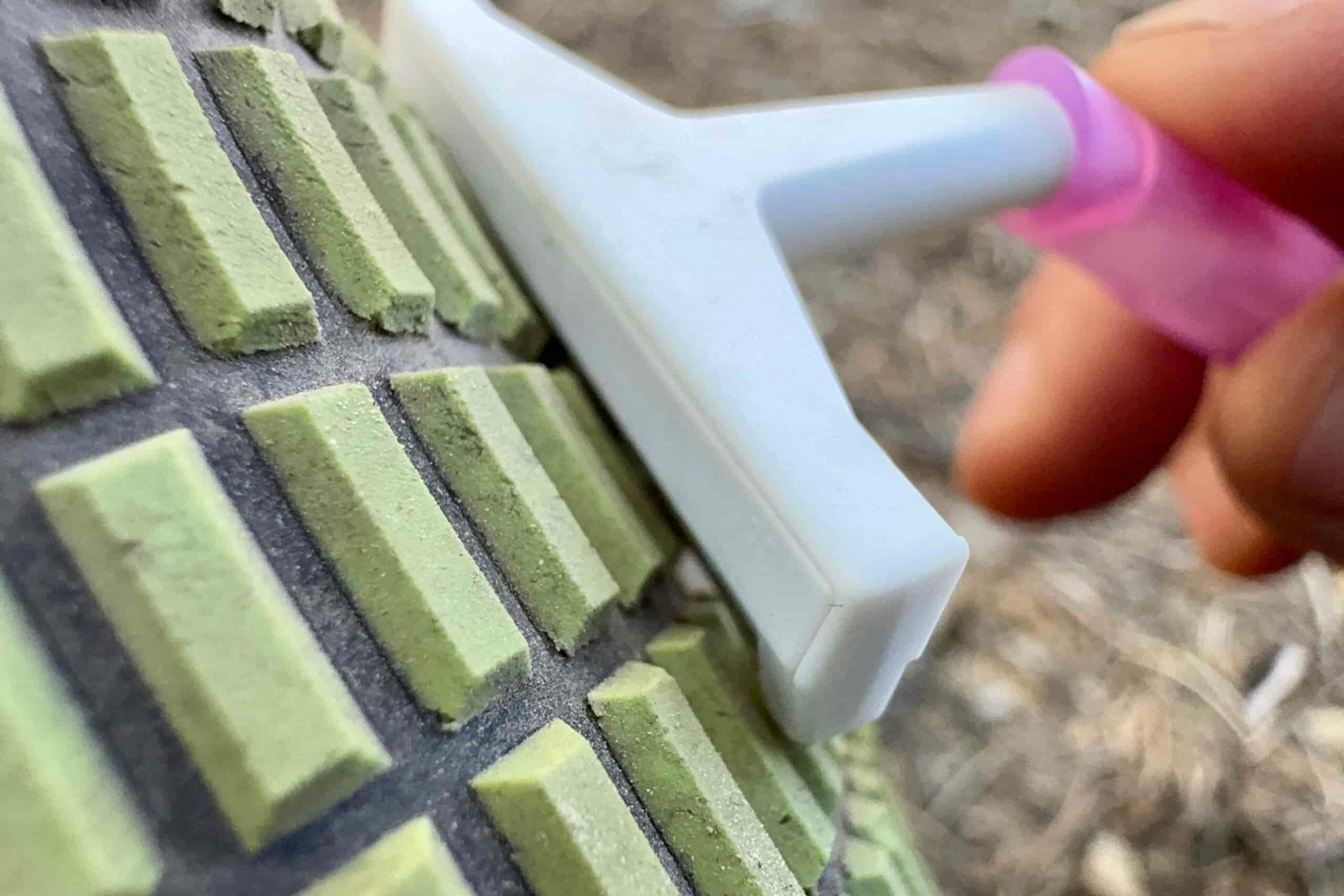 Close up of a razor being dragged across the tread of a Clawgs V3 boot.