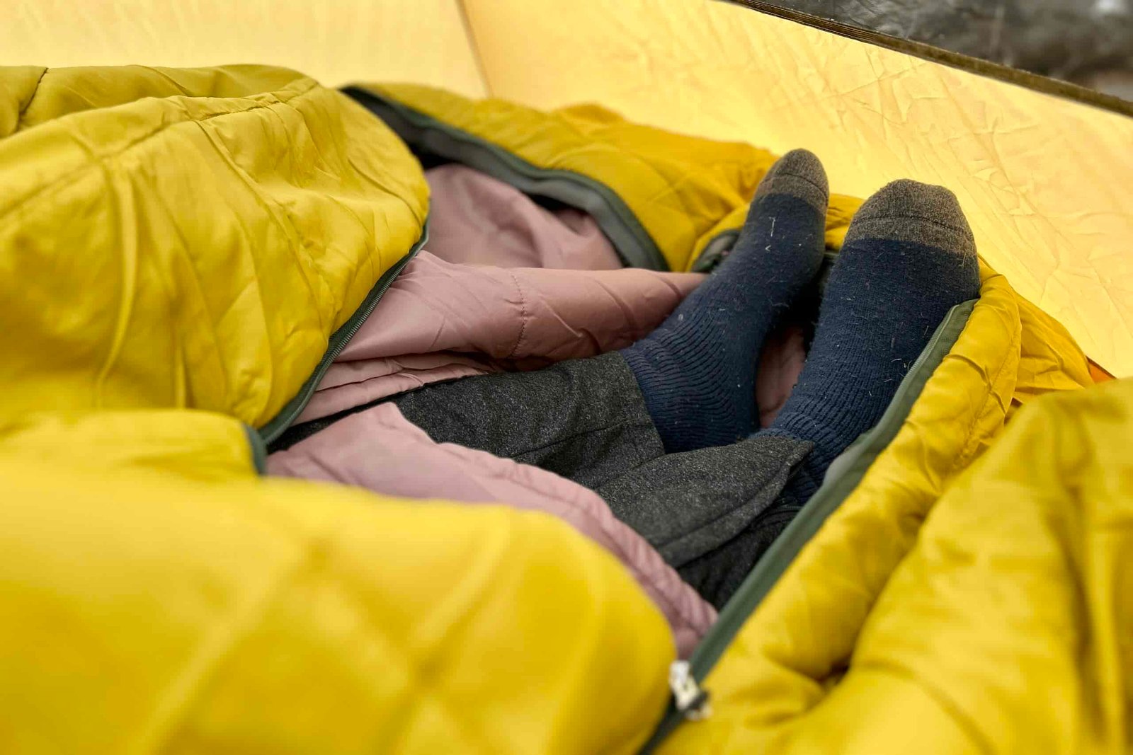 Close-up image of a person's feet sticking out of the bottom of a sleeping bag.