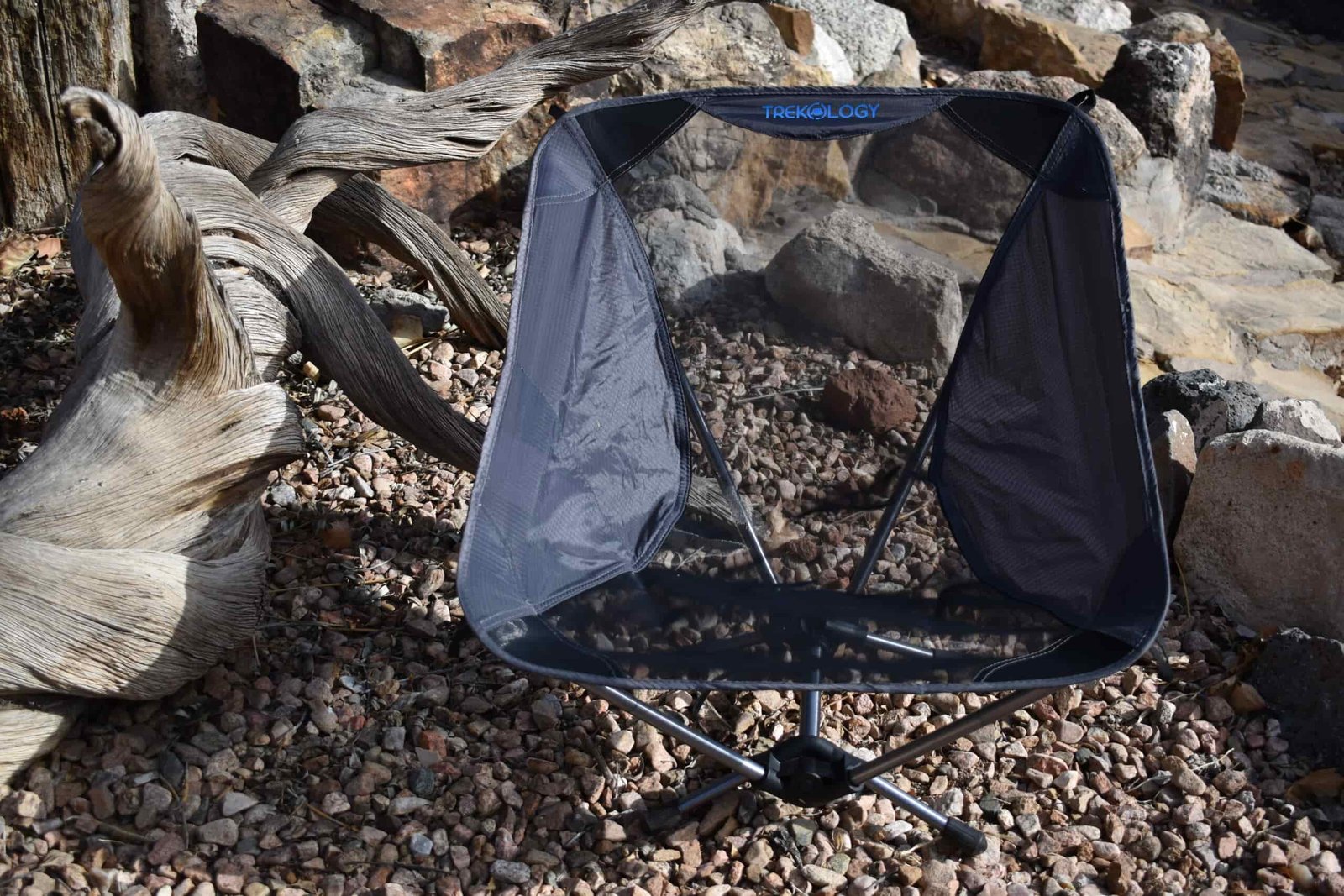 close up front view of the Trekology chair as it sits in a decorative rock garden