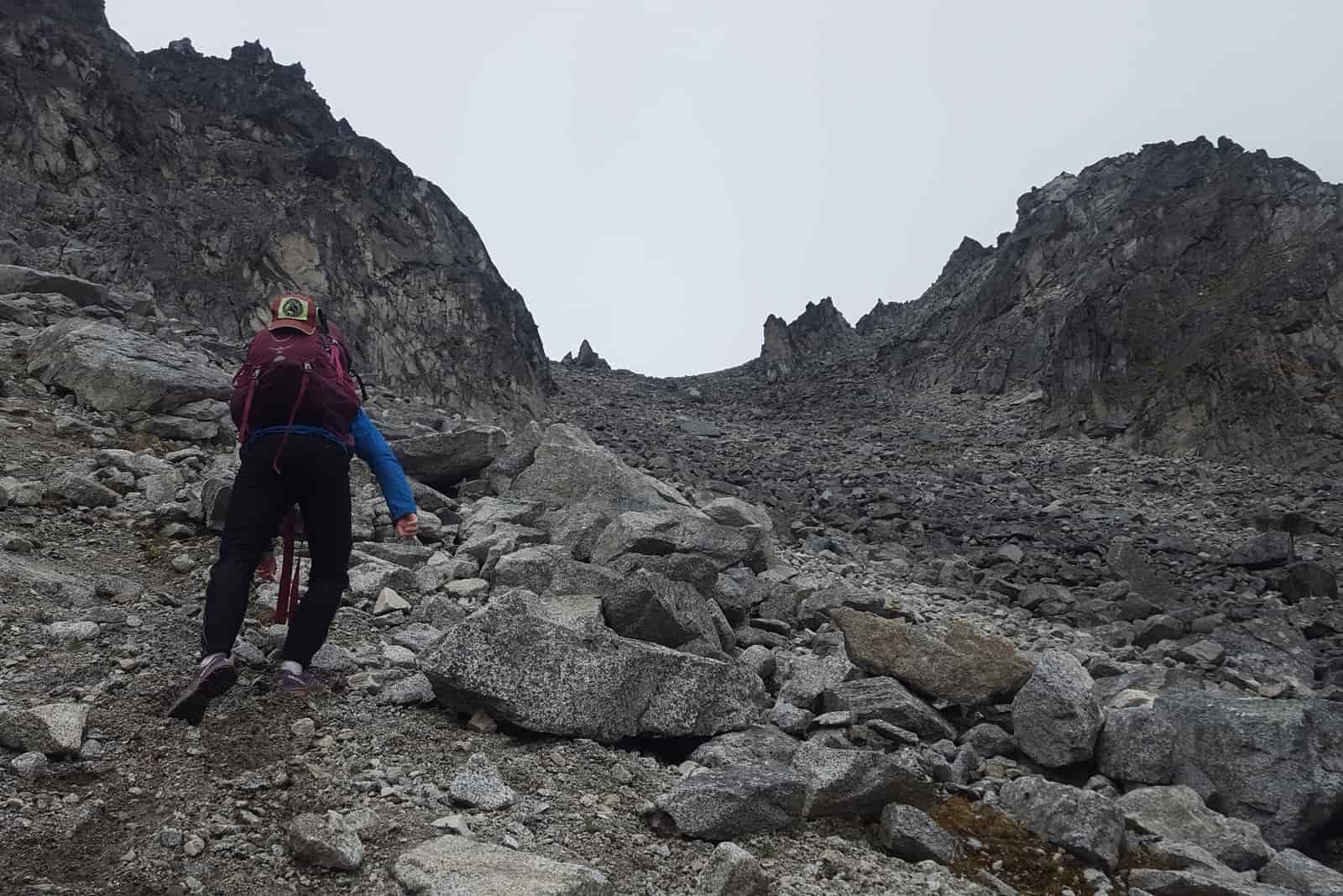 A woman climbs up a mountain pass