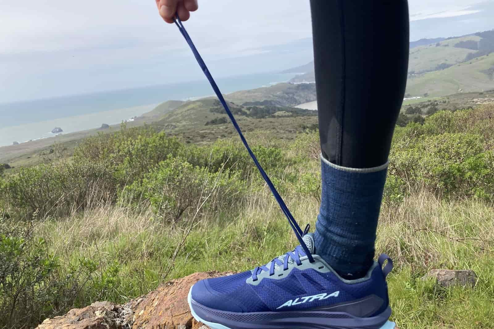 Person holding out the laces on the Altra Lone Peak to show their length.