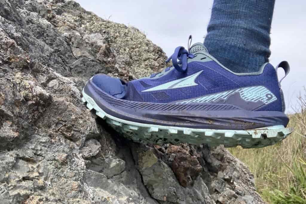 Close up showing the Altra shoe while climbing up a rock