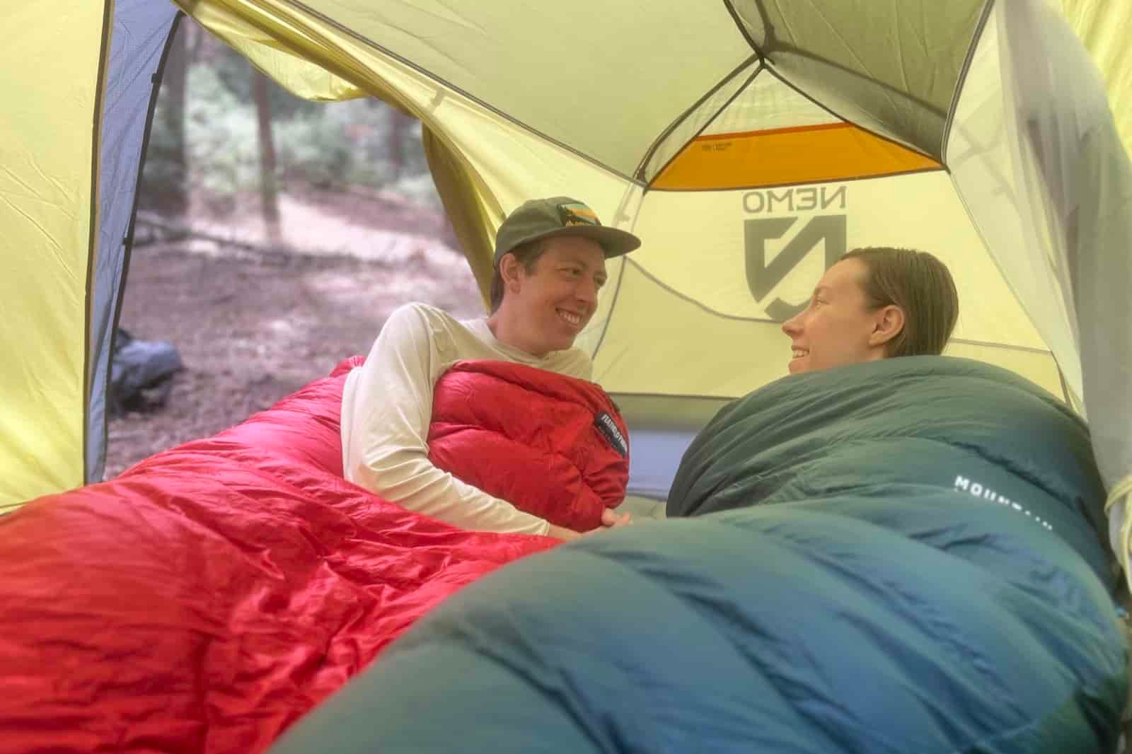 two hikers lay in sleeping bags in a tent