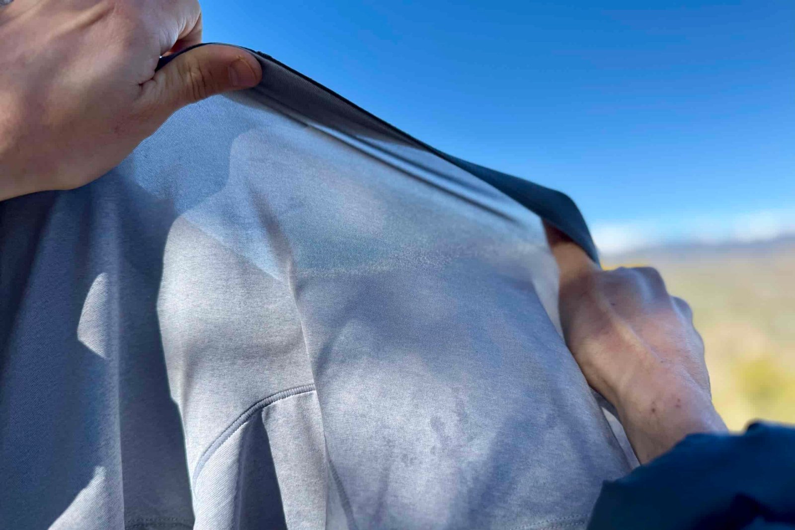 a pair of hands stretches a pair of underwear on a sunny day to show the thickness of the fabric