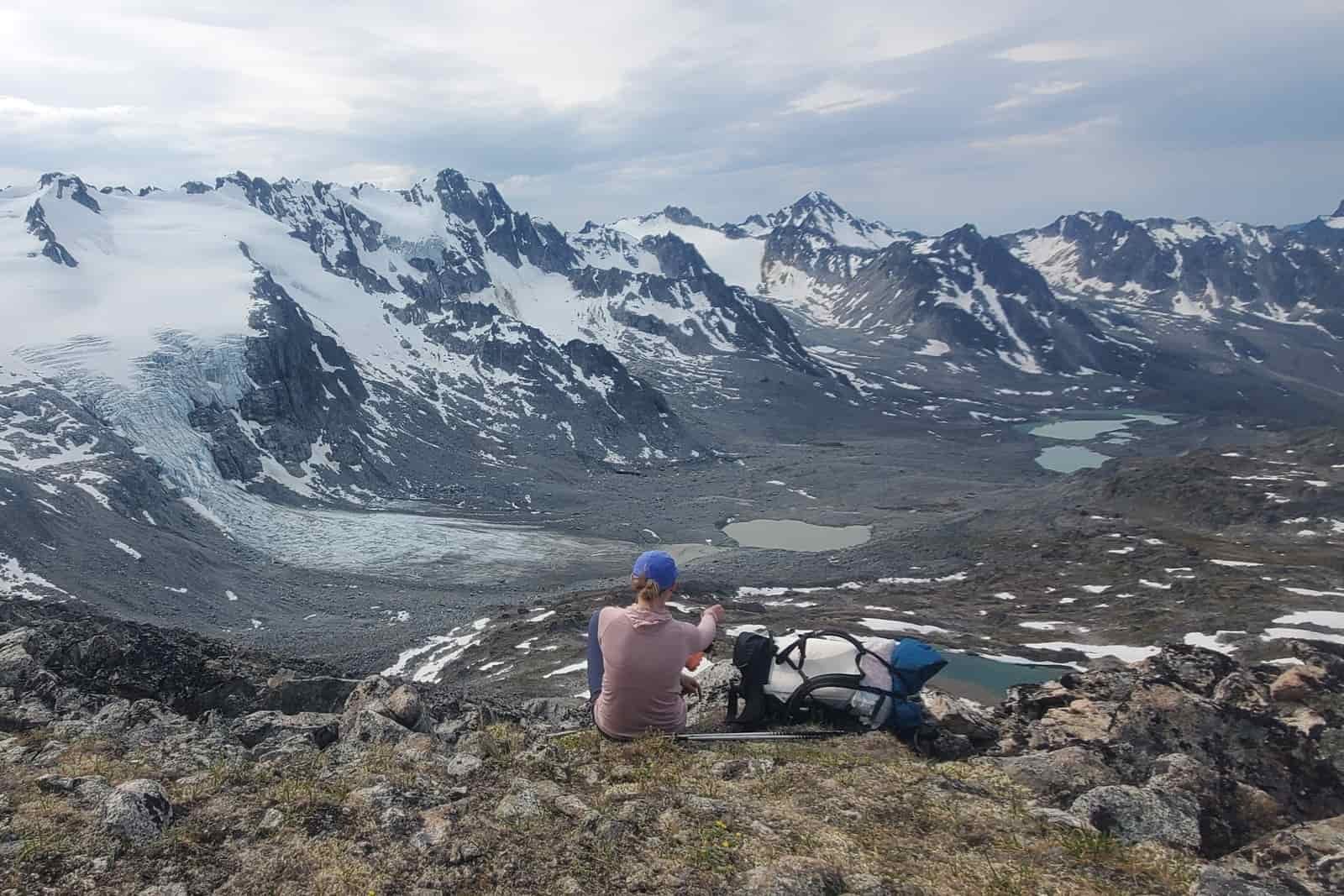 A woman rests on a mountain pass.