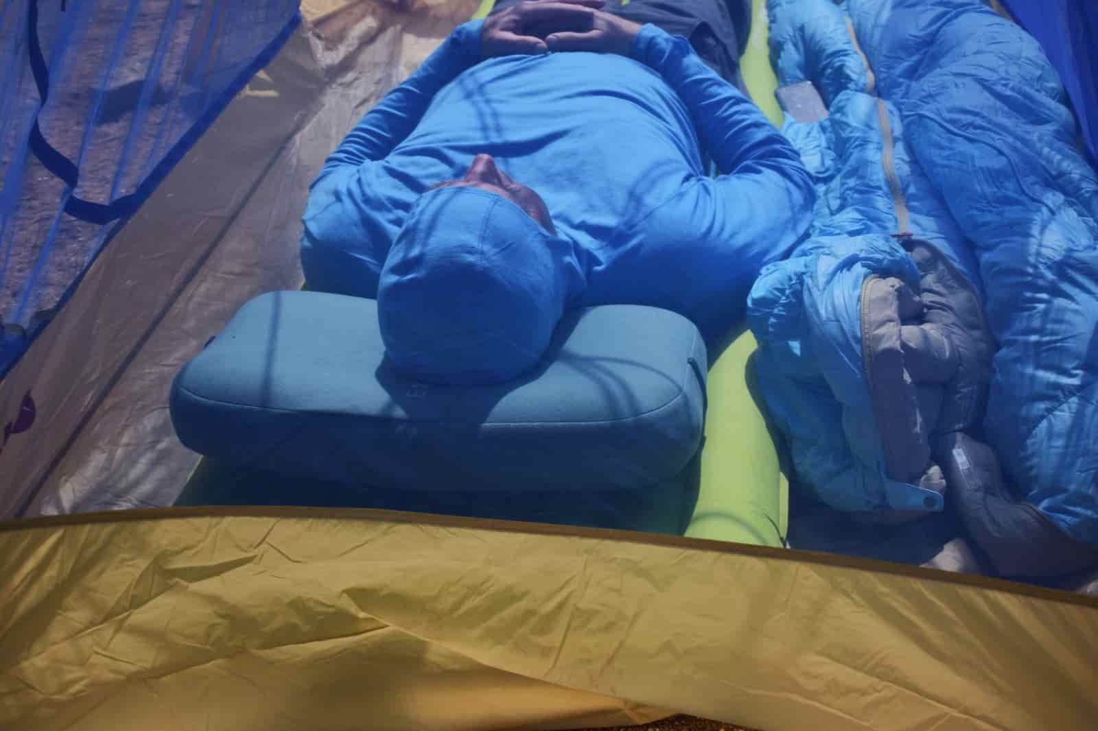 looking through a tent's mesh at a camper resting on the Exped Mega Pillow and Exped sleeping pad