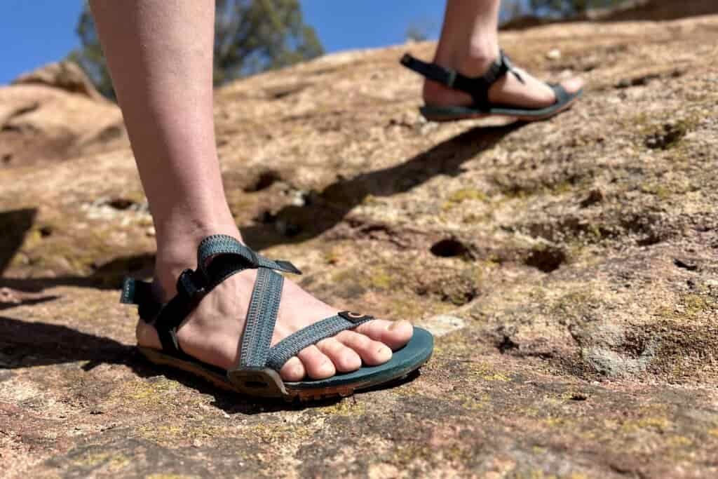 Close up image from knees down of a person wearing sandals.