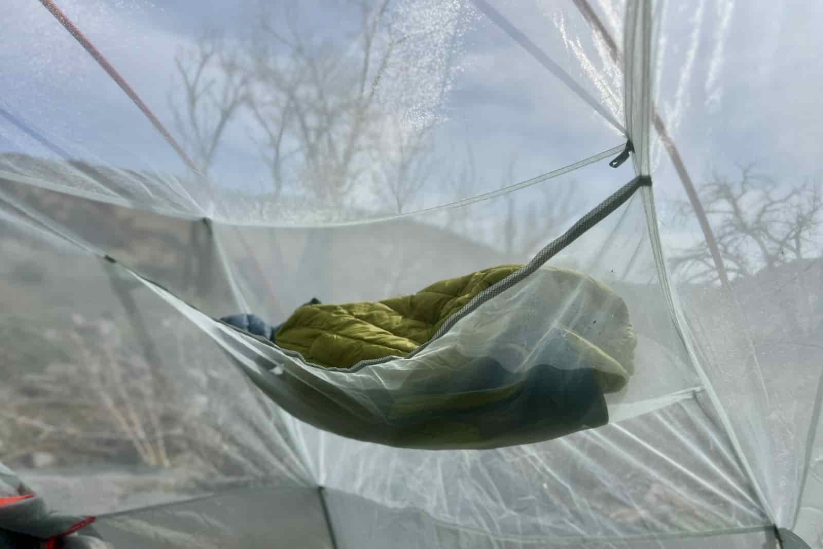 A puffy jacket in the mesh gear loft of a tent