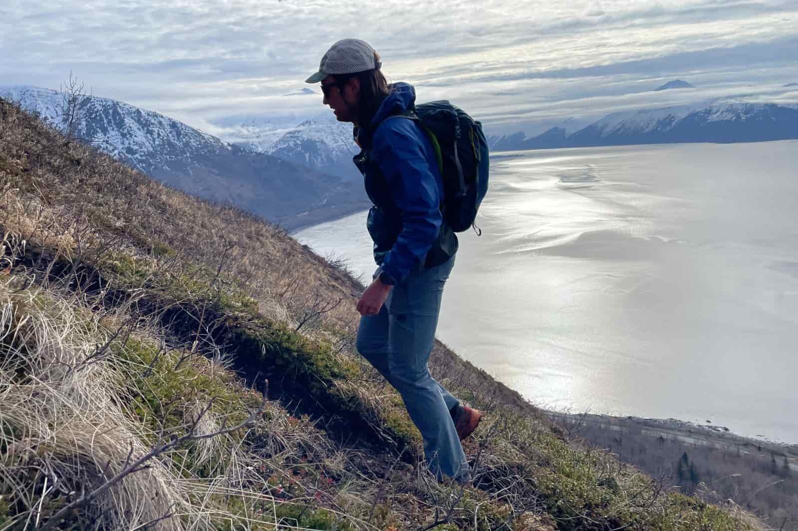 A man hikes up a steep hillside.