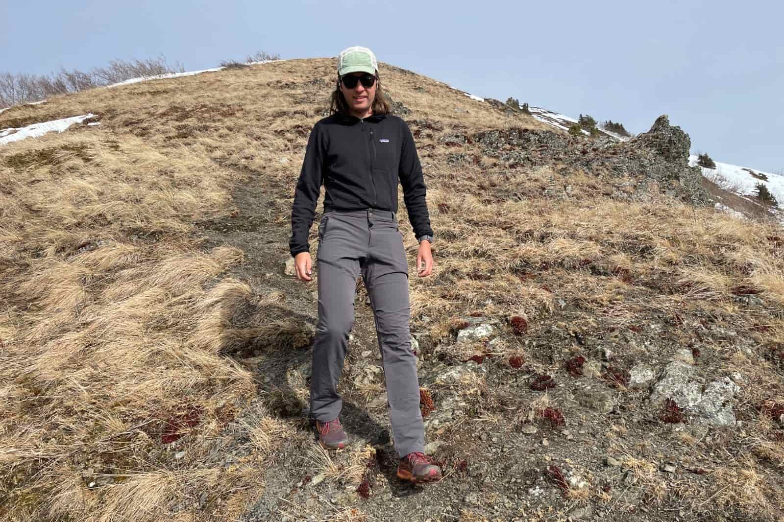 A man hikes downhill on a steep trail.