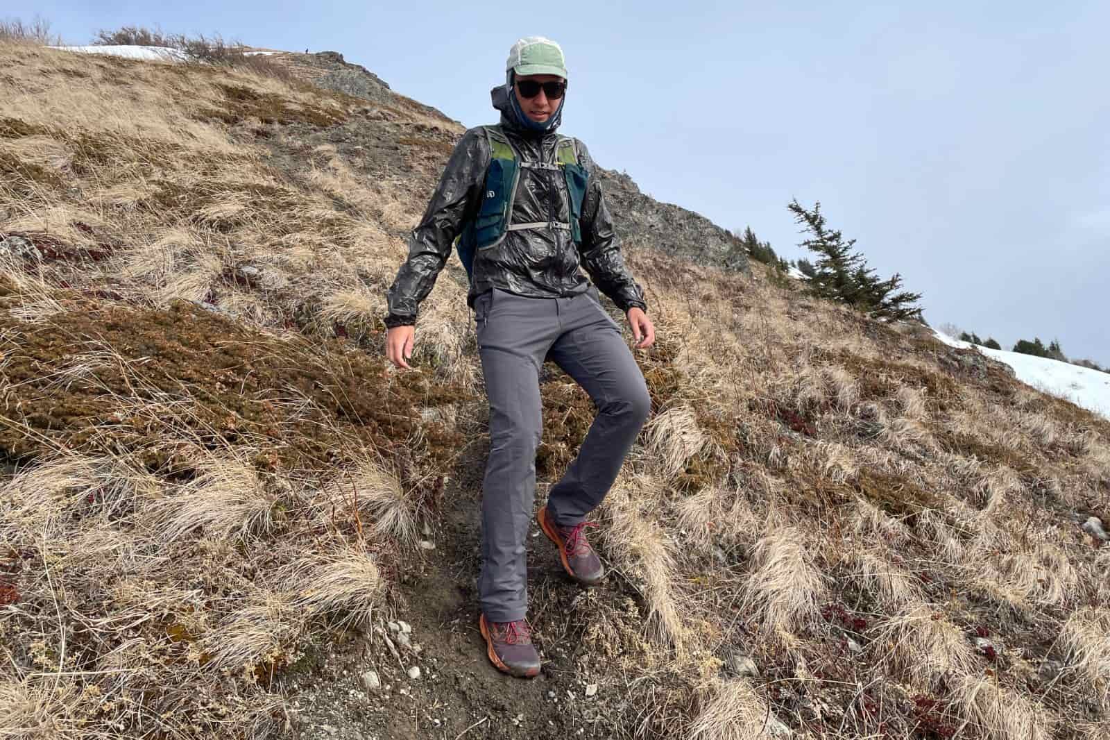 A man takes a step walking down a trail.