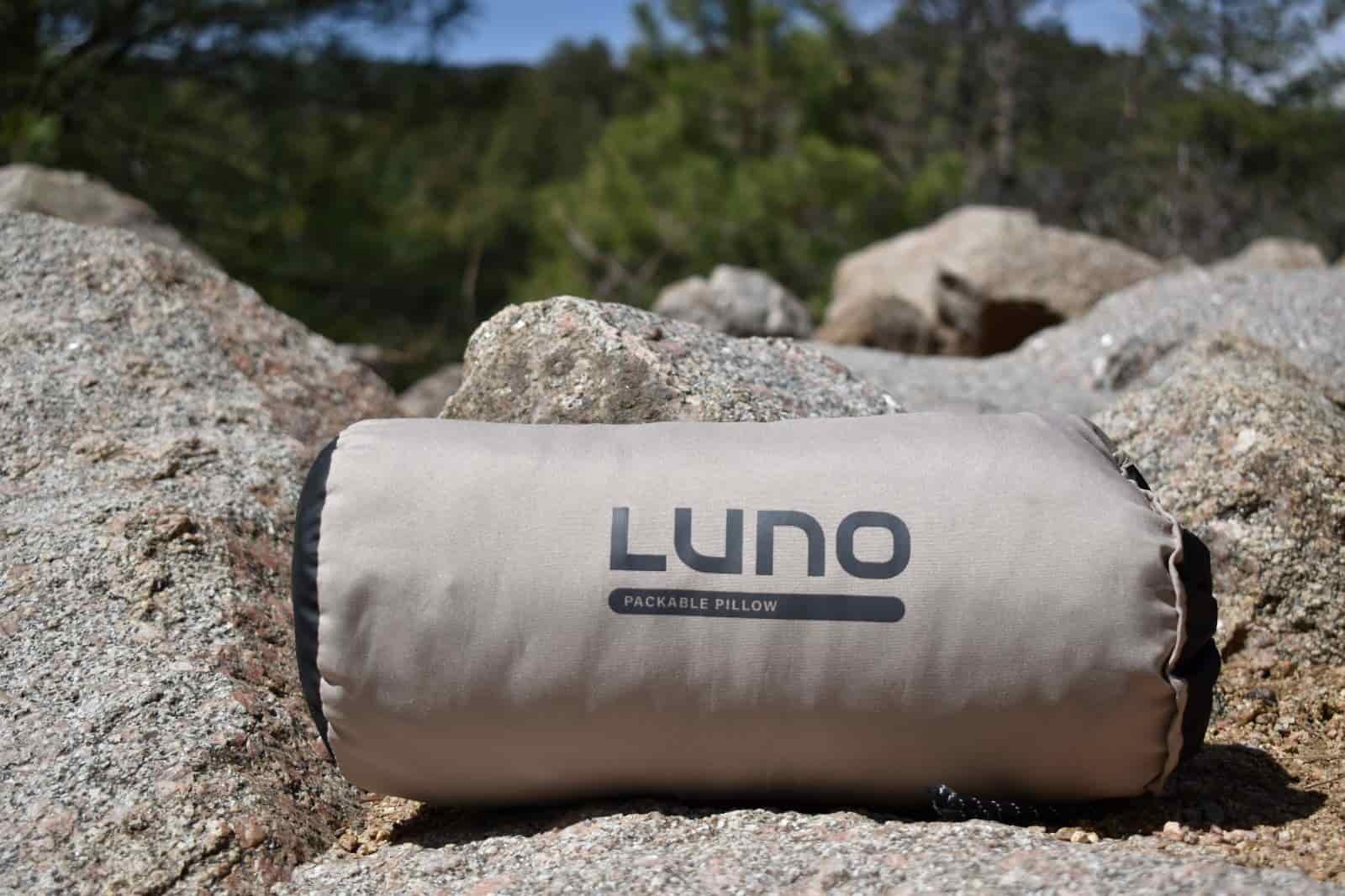 close up of Luno Packable Pillow packed into its stuff sack while resting on rocks